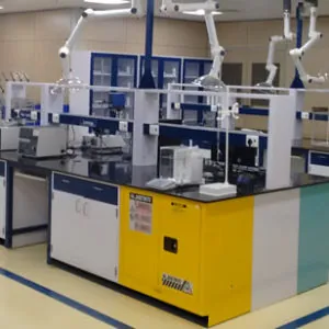 Laboratory with workbenches, fume extraction arms and a yellow flammable storage cabinet